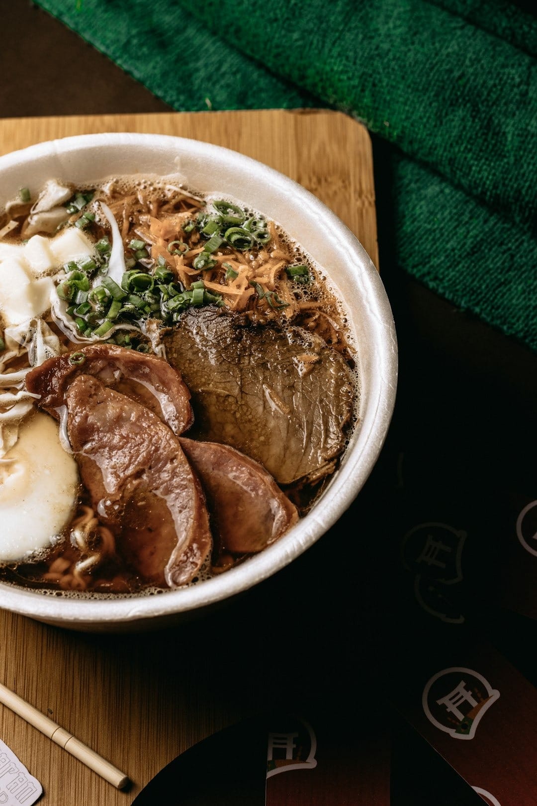 Steaming bowl of ramen with egg and green onions.